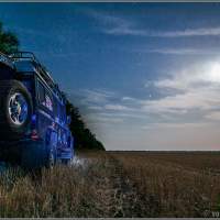 Ночь окутала кемпер Land Rover Defender на поле